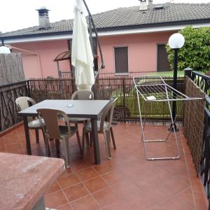 un patio con mesa, sillas y sombrilla en Appartamento BLU - Colori del Lago D'Orta - NUOVA STRUTTURA A OMEGNA en Omegna