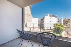 two chairs sitting on a balcony with a window at Newly renovated apt in the heart of Kerameikos in Athens