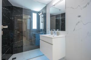 biała łazienka z umywalką i prysznicem w obiekcie Newly renovated apt in the heart of Kerameikos w Atenach