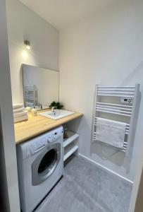 a bathroom with a washing machine and a sink at Le Cocon Landais - Clim - Balcon - Central - Spacieux - Lumineux in Mont-de-Marsan