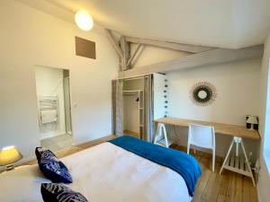 a bedroom with a large bed and a desk at Le Cocon Landais - Clim - Balcon - Central - Spacieux - Lumineux in Mont-de-Marsan