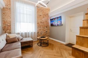 a living room with a couch and a brick wall at Võru Studio Apartment in Võru