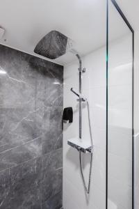 a shower with a shower head and a glass door at Võru Studio Apartment in Võru