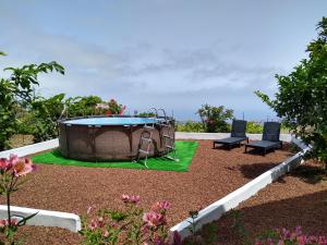 a patio with a trampoline and two chairs in a garden at Los Huertos Conect with the nature & relax in Icod de los Vinos
