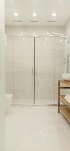 baño blanco con ducha y lavamanos en Elegant basement Suite, en Orosei
