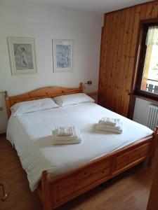 una camera da letto con un grande letto con due asciugamani di Casa Dolomiti a Moena