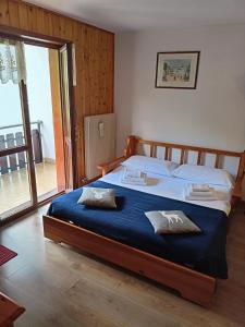 una camera da letto con un grande letto con una coperta blu di Casa Dolomiti a Moena