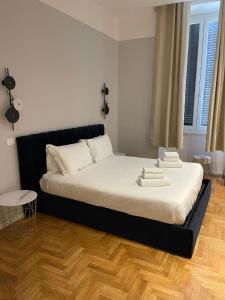 a bedroom with a bed with white sheets and a wooden floor at Carrara 24 in Rome
