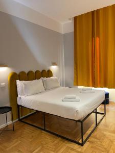um quarto com uma cama grande e lençóis brancos em Carrara 24 em Roma