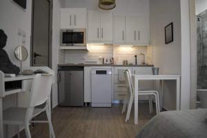 a kitchen with white cabinets and a table and chairs at Diamond studio Skala in Skala