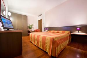 um quarto de hotel com uma cama e uma televisão de ecrã plano em Hotel Campelli em Sondrio