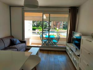 a living room with a couch and a tv and a table at leflamantduport in Hyères