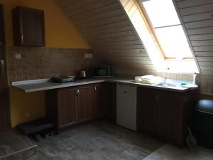 an attic kitchen with a sink and a window at Privat 66 in Liptovský Trnovec