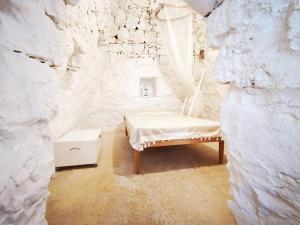a room with a bed in a stone wall at Trullo Salento a 2 passi dal mare - Apulia Home in Capilungo