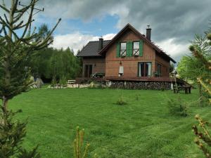 een huis met een groen gazon ervoor bij Apartament Zielone Okiennice in Lasowka