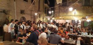 Une foule de personnes assises à des tables dans une pièce dans l'établissement Tramonti d'estate - Casa Vacanze, à Ortona