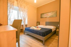 Un dormitorio con una cama y una mesa con toallas. en ALMA B&B Home Cosenza, en Cosenza