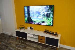 a flat screen tv on a yellow wall at DIAMOND TORREMOLINOS TROPICAL in Torremolinos