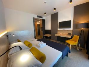 una camera d'albergo con 2 letti, una scrivania e una TV di Hotel Leonardo a Slovenska Bistrica