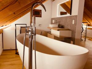 baño con bañera grande y lavamanos en Casa Mille Sassi, en Lionza