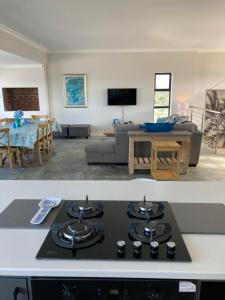 a kitchen and a living room with a stove top at Happy Days Holiday Home in Witsand