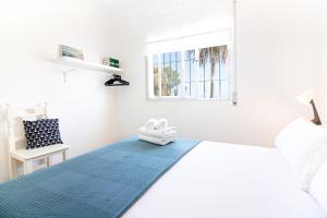 um quarto branco com uma cama e uma janela em Al Rolo Beach em Málaga