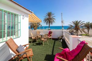 uma varanda com cadeiras e uma mesa e a praia em Al Rolo Beach em Málaga