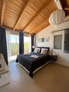 a bedroom with a bed and a large window at Swim on a private beach in Sounio