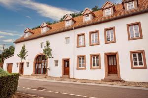 biały dom z brązowymi drzwiami i oknami w obiekcie Trasse Belge w mieście Trassem