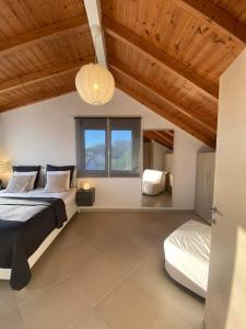 een slaapkamer met 2 bedden en een houten plafond bij Swim on a private beach in Sounio