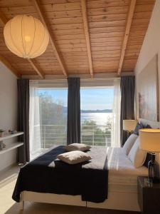 1 dormitorio con cama y ventana grande en Swim on a private beach en Sounio