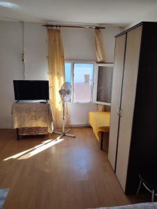a bedroom with a bed and a fan and a window at Hostel EMY Camere cu baie proprie aproape de plaja 3 Papuci in Constanţa