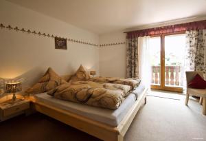 a bedroom with a bed and a large window at Pension Ambros in Büchlberg