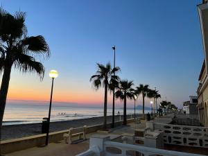 una spiaggia con palme e l'oceano al tramonto di Chalet Playa Miramar a Miramar