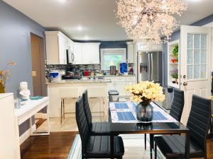 una cucina con tavolo da pranzo, sedie e lampadario pendente di RI Full House - Gym, Entertain & More a Cranston