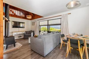 a living room with a couch and a table with a dining room at Splendour on Spencer - Lake Tarawera Holiday Home in Lake Tarawera