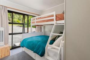 a bedroom with a bunk bed and a window at Splendour on Spencer - Lake Tarawera Holiday Home in Lake Tarawera