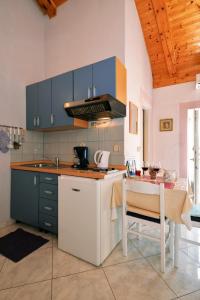 eine Küche mit blauen Schränken, einem Tisch und einem Herd in der Unterkunft Apartments with a parking space Murter - 5097 in Murter