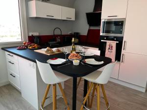 una cocina con una mesa con comida y copas de vino en Lostendro, appartements vue port, en Le Guilvinec
