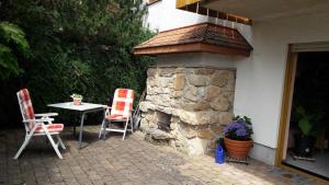 a patio with a table and chairs and a stone fireplace at Schwalli`s Fewo in Korbach