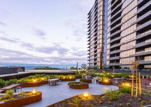 a large building with a courtyard with tables and lights at Astra Apartments Glen Waverley in Glen Waverley