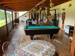 a pool table in the middle of a room with a table at Pensiunea Casa Domnitei in Baia de Fier