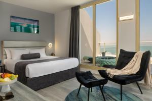 a hotel room with a bed and a chair at Leonardo Plaza Hotel Dead Sea in Neve Zohar