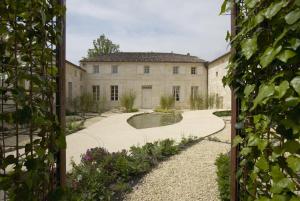 - une vue extérieure sur un bâtiment avec une cour dans l'établissement Maison De La Tour, à Saint-Émilion