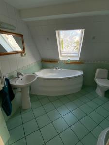 a bathroom with a tub and a sink and a toilet at Dom Na Zachodzie in Szczecinek +6 photos