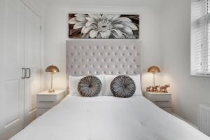 a white bedroom with a large white bed with two lamps at Modern Deluxe 5 Bed 3 Bath House London Camberwell Denmark Private Parking in London