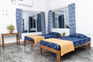 a room with two beds and two windows at BrightMoon_Homestay in Puducherry