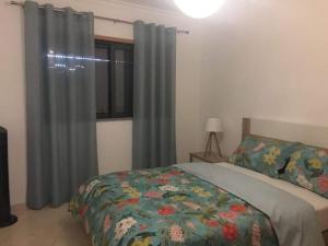 Schlafzimmer mit einem Bett und einem Fenster mit Vorhängen in der Unterkunft Apartamento Cacela- Manta Rota- Altura in Vila Nova De Cacela