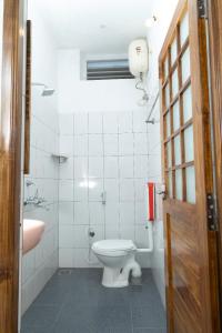 BrightMoon_Homestay في بونديتْشيري: حمام ابيض مع مرحاض ومغسلة