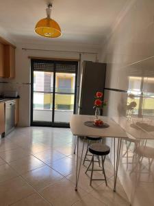 eine Küche mit einem Tisch und einer Blumenvase darauf in der Unterkunft Apartamento Cacela- Manta Rota- Altura in Vila Nova De Cacela